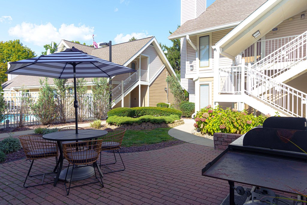 a patio with a table and chairs and an umbrella